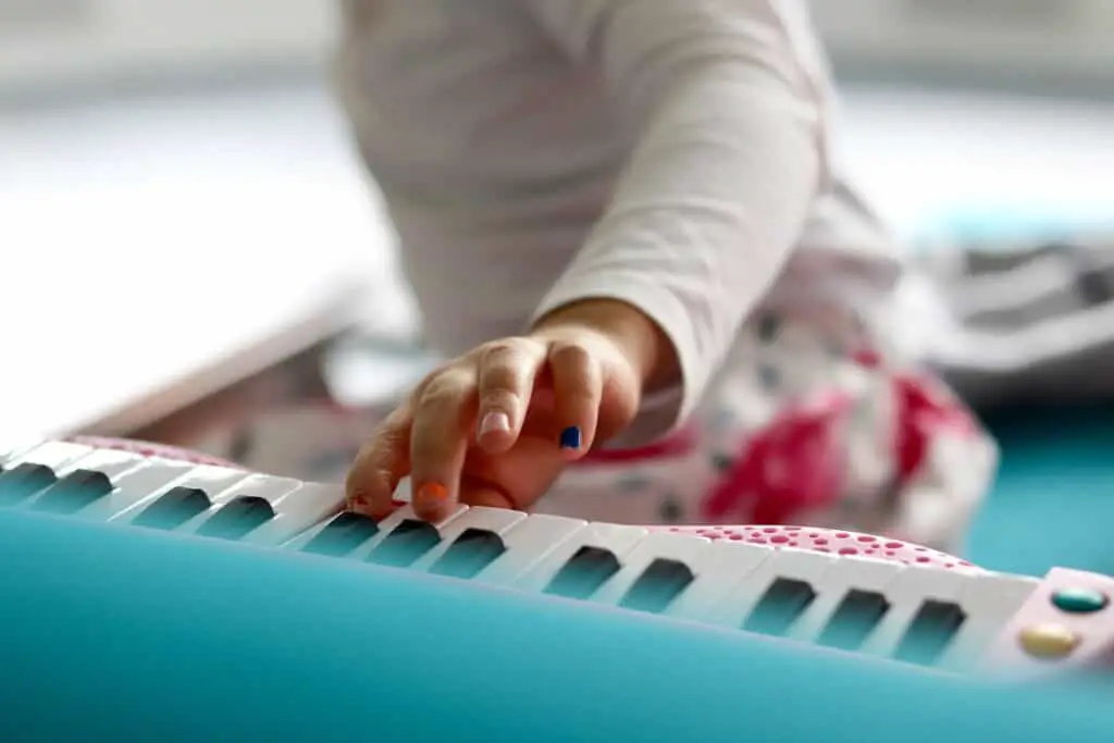 A child playing the piano with nail polish