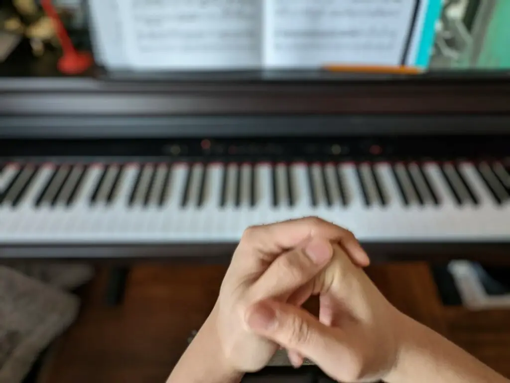 Picture of cracking knuckles in front of the piano
